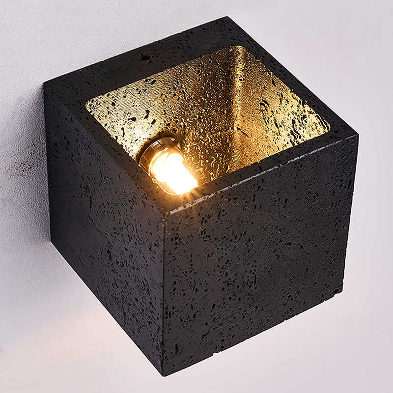 Square wall light fixture with black concrete exterior and gold interior on a white background