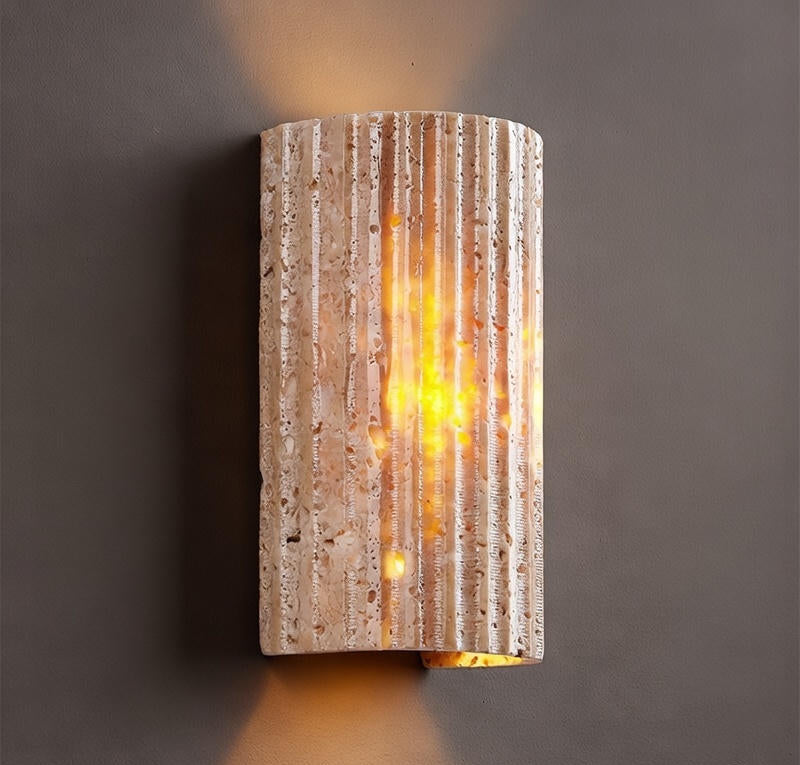 Textured wall sconce with warm glow on a dark background
